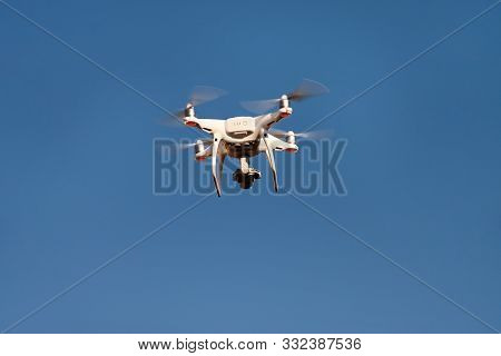 Drone Quad Copter Fly On Blue Sky In Background. Modern Drone Is Flying In Air, To Take Photos And R
