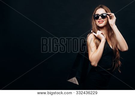 Beautiful Young Woman Posing With Paper Bag Of Purchases