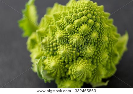 vegetable, food and culinary concept - close up of romanesco broccoli on table
