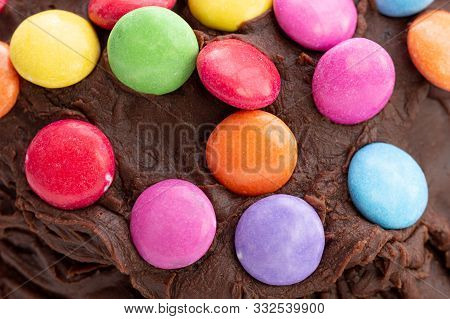 Kids Celebration Cake. Close Up Detail Of Colorful Chocolate Beans On Chocolate Frosting That Is Sli