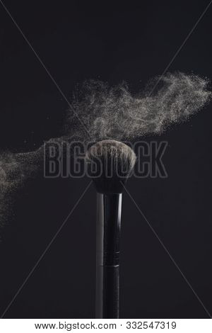 Powderbrush With Cloud Of Face Powder On Black Background.