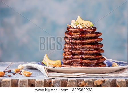 Vegan Pancakes Based Avocado With Cocoa And Date Syrup. Vegan Healthy Sweet Food. Blue Background