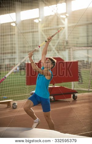 Pole Vaulting - Man In Blue Shirt Is Going To Jump With Pole