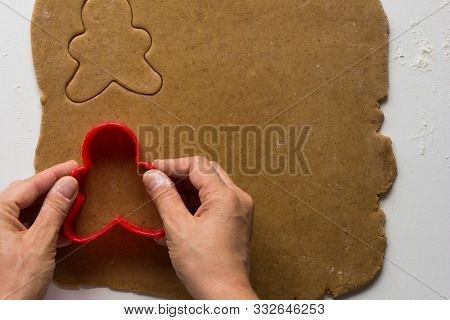 Woman Hands Cutting Forms Of Man On Rolled Out Gingerbread Dough On White Background