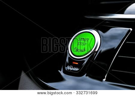 Car Dashboard With Focus On Green Engine Start Stop Button. Modern Car Interior Details. Start/stop 