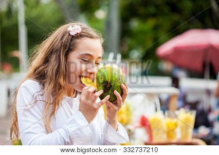 Beautiful Young Girl At Paseo Bolivar Square In The City Of Cali Eating Tropical Fruits In Colombia