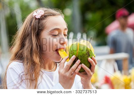 Beautiful Young Girl At Paseo Bolivar Square In The City Of Cali Eating Tropical Fruits In Colombia