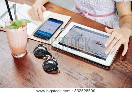 Woman Comparing Price Of Sunglasses And Ammount Of Money On Her Bank Account, Selective Focus