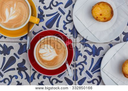 Two Cups Of Coffee Latte In Ceramic Cups With Traditional Portuguese Dessert Pastel De Nata. Top Vie