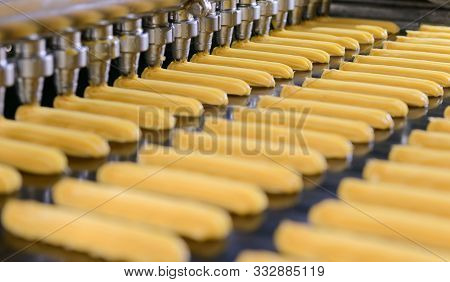Cakes On Automatic Conveyor Belt Or Line, Process Of Baking In Confectionery Culinary Factory Or Pla