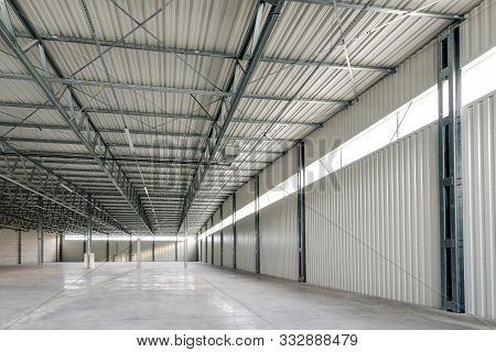 Empty clean white warehouse with daylight windows