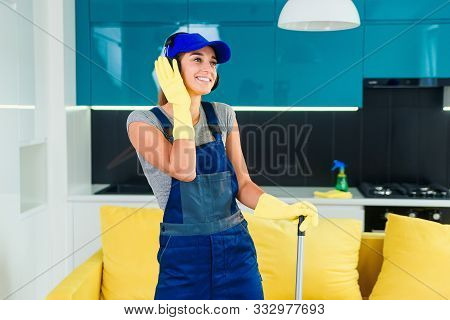 Attractive Female Worker With Headphones Dancing With The Swabber In The Middle Of The Contemporary 