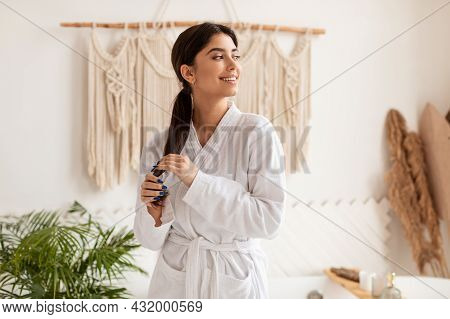 Young Lady Touching Hair In Ponytail Posing In Bathroom Indoor