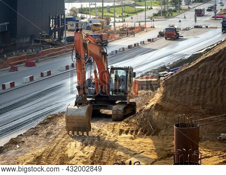 A Crawler Excavator Works At A Construction Site Next To The Road. Urban Construction Background Wit