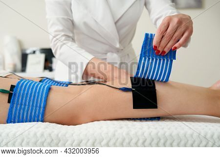 The Procedure Of Myostimulation On Legs Of A Woman In A Beauty Salon. Caring For The Body With Elect