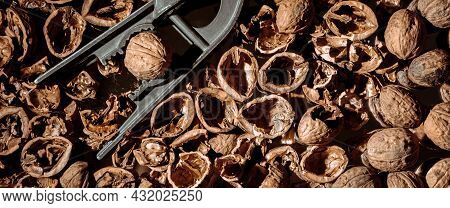 Walnut In A Nutcracker Close-up. Dark Background. Beautiful Background With Food. Healthy Ingredient