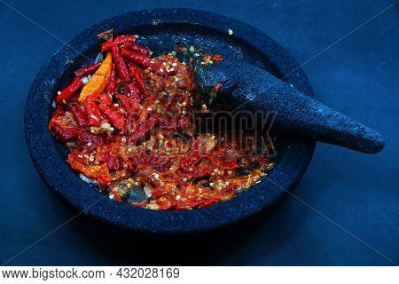 Red Chili Sauce On A Stone Mortar And Pestle. Dark Background, Focus Selected.