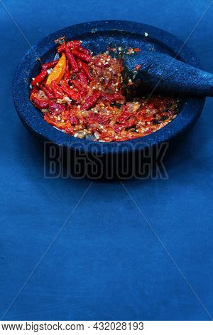 Red Chili Sauce On A Stone Mortar And Pestle. Dark Background, Focus Selected.