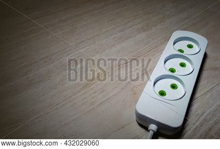 3 Outlet Extension Cord On A Wooden Surface