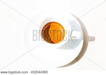 Round White Coffee Cup On White Surface. High Contrast Picture. Traditional Italian Ristretto In Bri