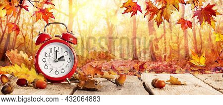 Fall Back Time - Daylight Savings End - Clock Alarm And Leaves In Autumn Background