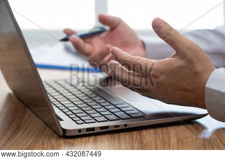 Action Working Concept : Close Up Hand A Man Describing Tasks In An Online Meeting With Laptop Compu