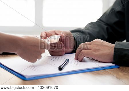 Man Accepting Credit Card From Women For Payment Of Car Insurance With The Officials Are Introducing