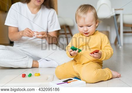 Child Hands Playing With Colorful Playdough. Moulding From Plasticine On Floor. Playing With Clay At