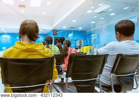 Back View Of Female Customers Sitting And Wait In Queues To Financial Transactions With The Bank Sta