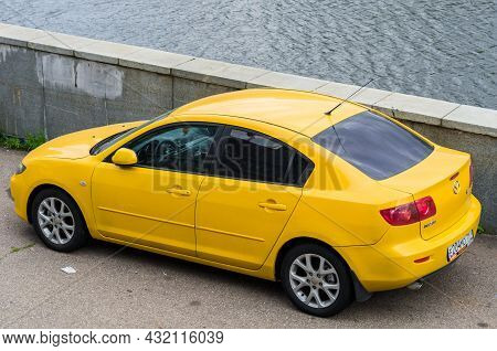 Moscow, Russia - September 2021: Yellow Mazda 3 Car Is Parked On The Embankment Near The Water. Rear