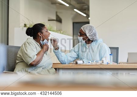 Medical Professional Doing Covid-19 Test To Woman With Throat Swab Probe