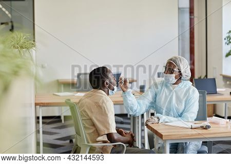 Medical Nurse In Ppe Suit Explaining Patient How She Will Get Sample For Coronavirus Testing