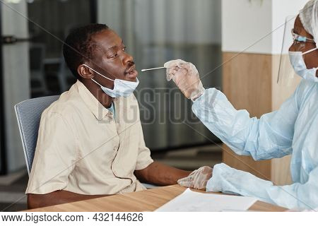 Black Man Opening Mouth To Let Doctor To Take Nasal Swab To Collect Sample To Covid-19 Test
