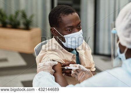 Black Man In Medical Mask Getting Shot Of Covid-19 Vaccine In Hospital