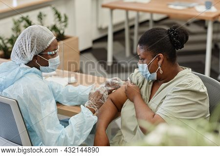 Black Woman In Protective Face Mask Getting Vaccinated Against Coronavirus In Hospital