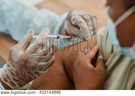 Close-up Image Of Of African-american Woman Getting Vaccinated At Medical Clinic During Coronavirus 