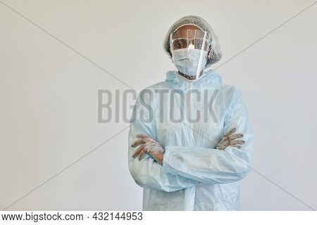 Serious Nurse In Ppe Suit, Medical Mask And Gloves, Crossing Arms And Looking At Camera, Isolated Of
