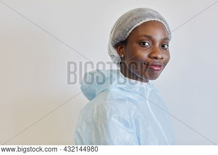Portrait Of Beautiful Sweaty Young Smiling Medical Nurse In Ppe Suit Lookig At Camera