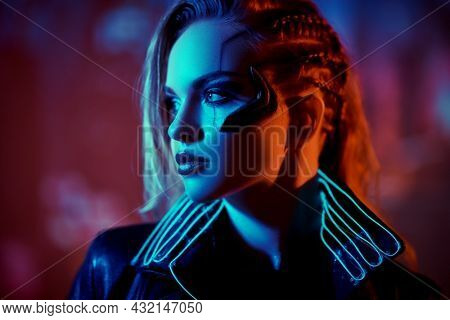 Cyberpunk concept. Close-up portrait of a beautiful cyberpunk girl standing against the backdrop of the night city of the future. Technology and fashion. 
