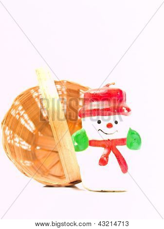 Un natale neve bambola candela e un cesto di vimini giallo Isolated On White Background