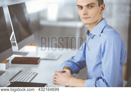 Young Successful Businessman Works With Computer, Sitting At The Desk In A Modern Office. Headshot O