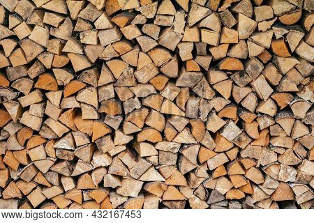 Texture Background Image Of Chopped Firewood Stacked In A Woodpile. Copy Space