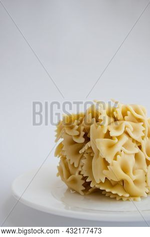 Cooked Farfallini Pasta In A Shape Of Square On A White Plate Closeup.