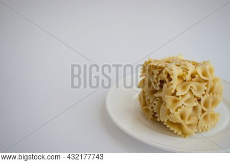Cooked Farfallini Pasta In A Shape Of Cube On A White Plate. Copy Space.