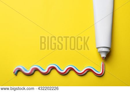 Blank Tube With Squeezed Out Toothpaste On Yellow Background, Flat Lay. Space For Text