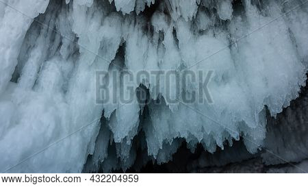 Icicles Hang From The Roof Of The Cave Like Natural Lace. Bizarre Stalactite Ice Close-up. In Detail