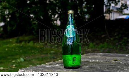 NORWALK, CT, USA - SEPTEMBER 3, 2021:  Bottle with Perrier water on wooden table outside