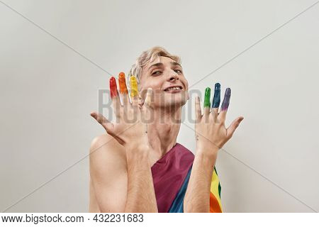 Proud Young Transgender Smiling Aside And Showing Fingers In Colorful Rainbow Lgbtqi Paint, Posing I