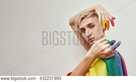 Creative Young Transgender Looking At Camera And Holding Hands Near His Head With Fingers In Colorfu