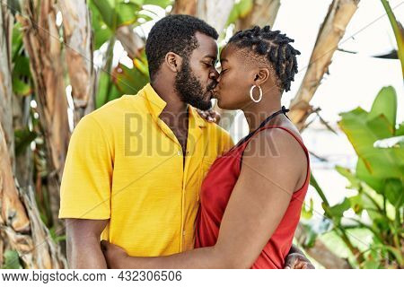 Young afircan american couple hugging and kissing standing at the city.